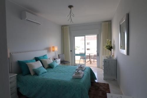 um quarto com uma cama com uma colcha verde em APARTAMENTO MICÁ em Albufeira