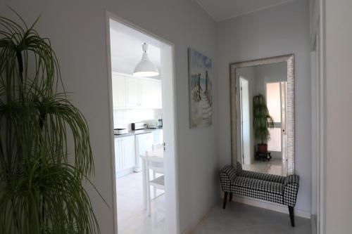 a hallway with a mirror and a chair in a room at APARTAMENTO MICÁ in Albufeira