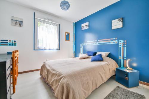 - une chambre bleue avec un lit et un mur bleu dans l'établissement Villa d'Eau Douce, à La Mothe-Achard