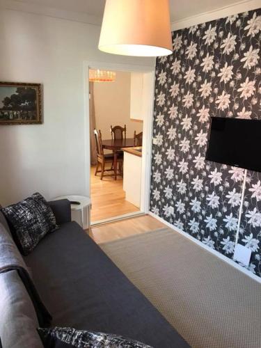 a living room with a couch and a wall with flowers at Kisa Wärdshus & Hotell in Kisa