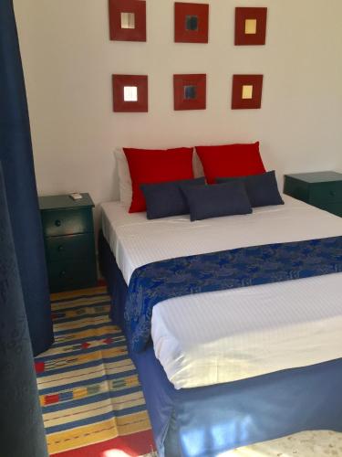a bedroom with two beds with red and blue pillows at Vangelios Apartments in Paphos