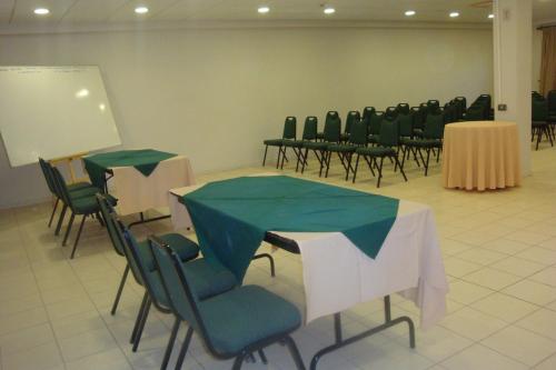 a conference room with tables and chairs and a white at Hotel Diego de Almagro San Pedro De Atacama in San Pedro de Atacama