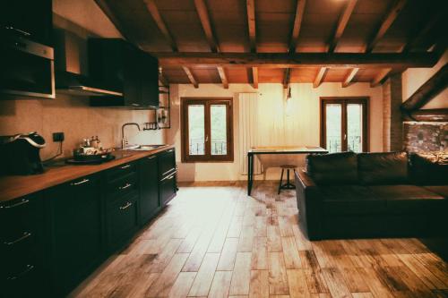 a kitchen and living room with a couch and a table at LA MAESTA' in Langhirano