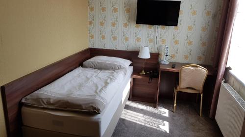 a bedroom with a bed and a desk and a television at Hotel Lipa in Bojnice
