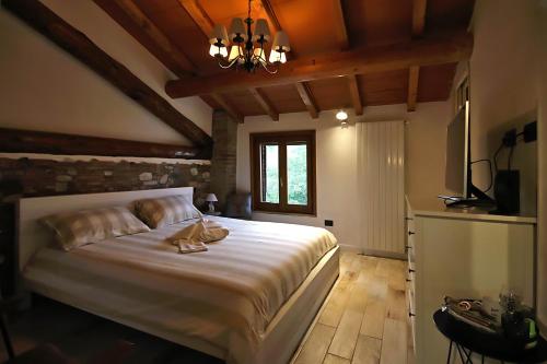 a bedroom with a large white bed and a window at LA MAESTA' in Langhirano