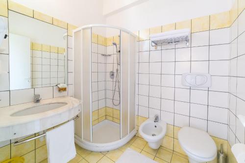 uma casa de banho com um lavatório e um WC. em Hotel Garisenda em Misano Adriatico