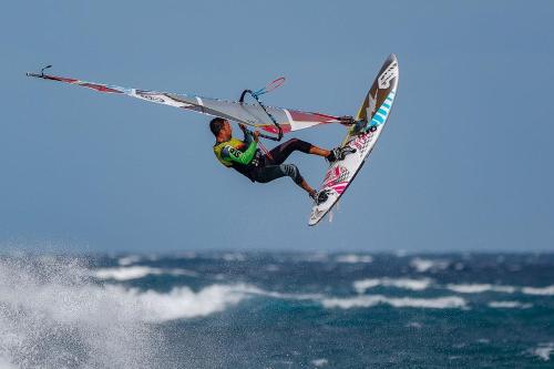 エル・メダノにあるAvenue Studyのサーフボードに乗って空を飛ぶ男性