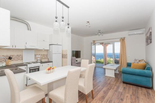 a kitchen and living room with a white table and chairs at Apartments Natasa in Sveti Stefan