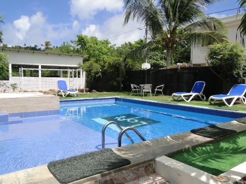 uma piscina com cadeiras azuis e uma casa em Casa Loft em San Andrés