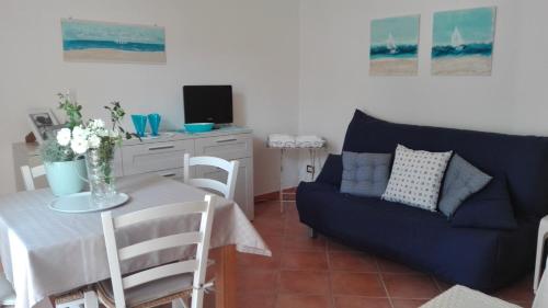 salon ze stołem i niebieską kanapą w obiekcie Le Caravelle w mieście Portoscuso