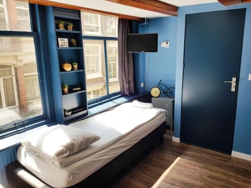 a bedroom with a bed in a room with a window at Urban Vibes Guesthouse in Amsterdam