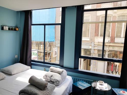 a room with a bed and a large window at Urban Vibes Guesthouse in Amsterdam