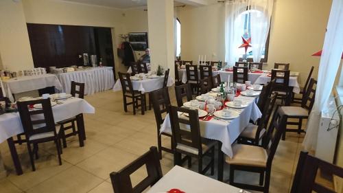 a dining room with white tables and chairs at Willa Pawlikowskich in Poronin