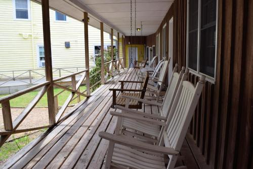 a row of chairs sitting on the porch of a house at Blackbeard's Lodge in Ocracoke