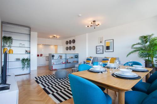 a dining room and living room with a table and blue chairs at Liiiving in Porto | Downtown Secret Luxury Apartments in Porto