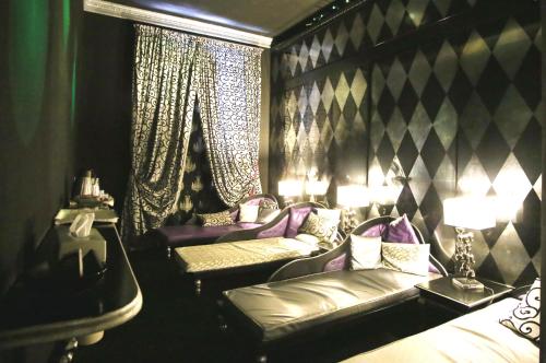 a room with two couches and curtains and a bed at Hotel Columbia Wellness & Spa in Montecatini Terme