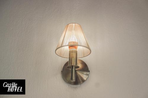 a wall light with a lamp on a wall at Castle Hotel in Gjirokastër