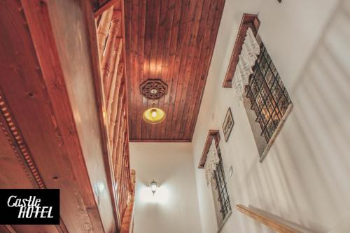 a hallway with a wooden ceiling and stairs at Castle Hotel in Gjirokastër