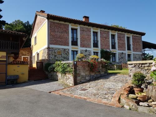 une grande maison en briques avec un mur en pierre dans l'établissement Fancornio Rural, à Zancornio