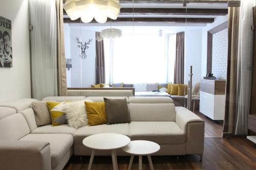 a living room with a couch and two tables at Apartmán 16 Romantika Chopok Juh Tále in Tale