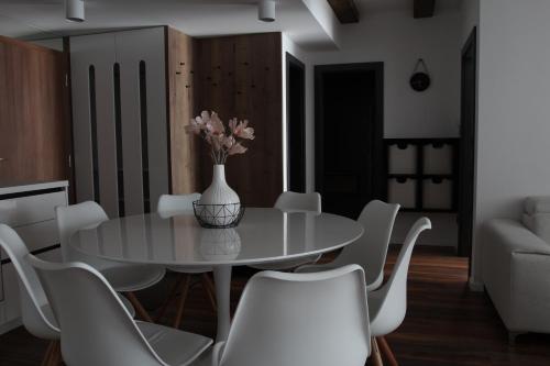 a dining room with a white table and white chairs at Apartmán 16 Romantika Chopok Juh Tále in Tale