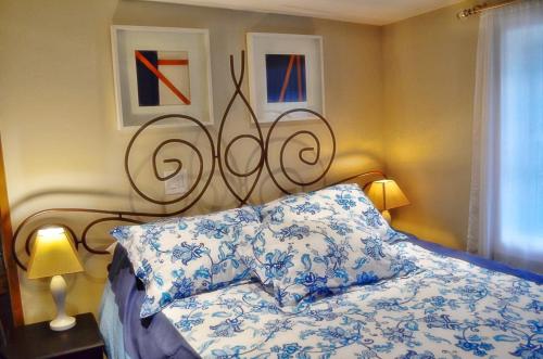 a bedroom with a bed with blue and white pillows at Romantic, Magical Cottage in Catskills nr Woodstock in Willow