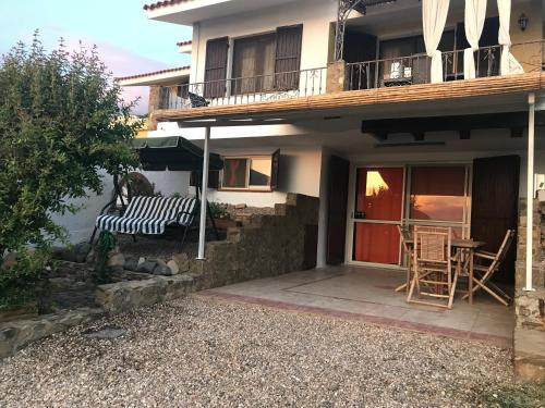 a house with a porch with a bench and a table at Casa Lugori in Torre Dei Corsari