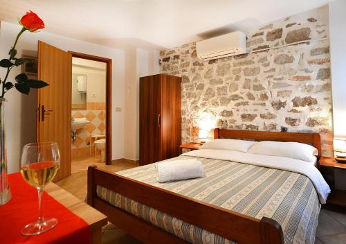 a bedroom with a bed and a wine glass on a table at Old Town Vrsar, apartments Danica & Zoran in Vrsar