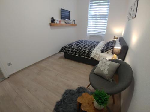 a bedroom with a bed and a chair and a couch at Apartments Sari in Sarajevo