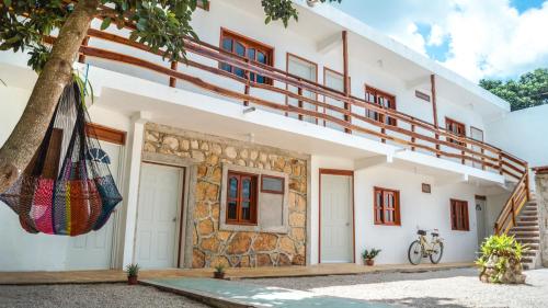 a house with a balcony and a tree at Hotel el Manglar in Bacalar