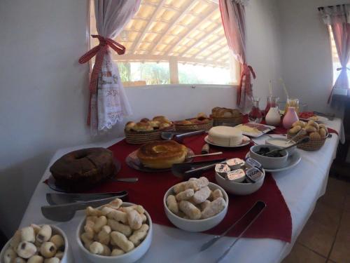 un tavolo con molti tipi diversi di cibo su di esso di Pousada Fecho da Serra a Capitólio