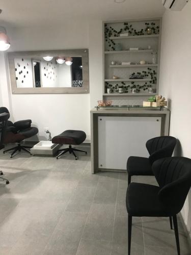 a waiting room with chairs and a table and a mirror at Hotel Anapoima in Anapoima