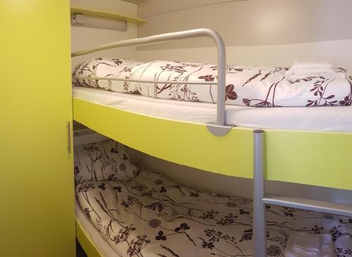Ce lit superposé se trouve dans une petite chambre dotée d'un lit superposé gmaxwell gmaxwell. dans l'établissement Simonai Mobile Homes, à Čezsoča