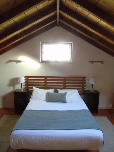 a bedroom with a large white bed with a window at Casa dos Salgueiros in Faja Grande