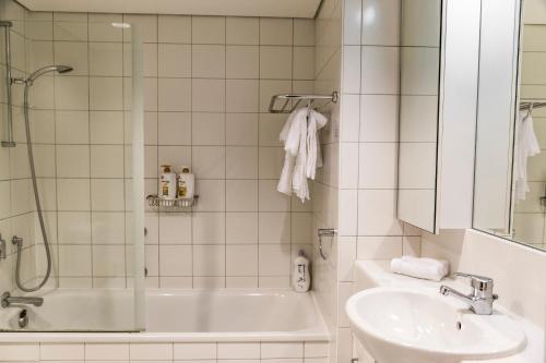 y baño con ducha, lavabo y bañera. en Picture Perfect Hotel Living, en Auckland