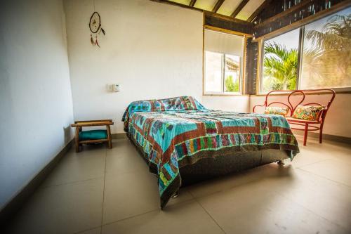 Un dormitorio con una cama y dos sillas y una ventana. en Indigo Palomino, en Palomino