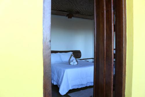 a bedroom with a bed with white sheets at Chale Vista Encantada in Lavras Novas