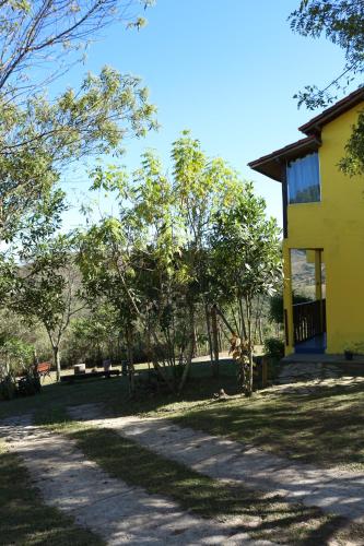 a yellow house with trees in front of it at Chale Vista Encantada in Lavras Novas