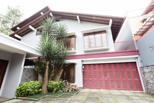 a house with a red garage door at Rumah Pelita near Lembang FREE WIFI - Villa Lantera in Bandung