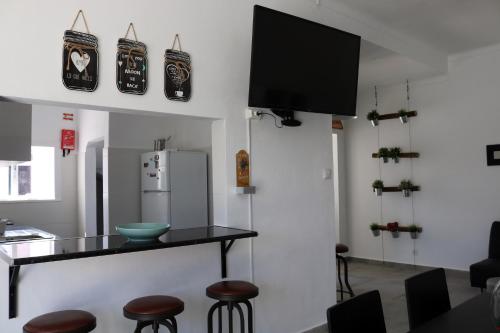 a kitchen with a counter with stools and a refrigerator at In My House in Castro Verde