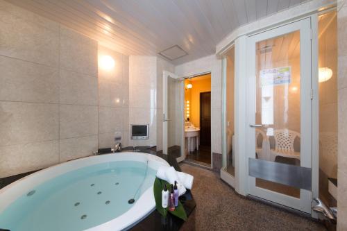 a large bathroom with a tub and a television at Canon Himeji Higashi (Adult Only) in Himeji