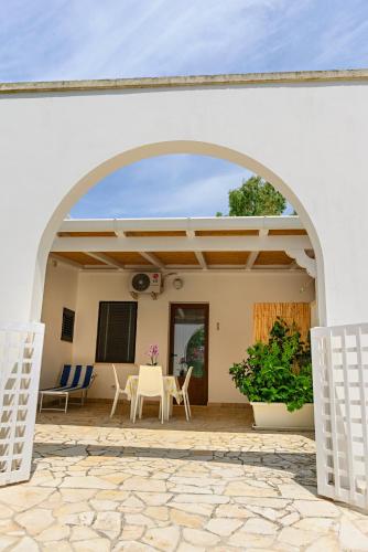 an archway leading to a patio with a table and chairs at Agriturismo Masseria Terra D'Otranto in Otranto