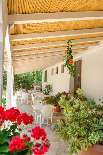 a patio with tables and chairs and flowers at Agriturismo Masseria Terra D'Otranto in Otranto