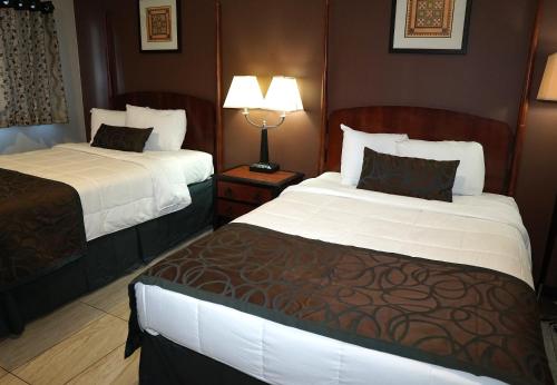 a hotel room with two beds and a lamp at Beachside Resort in Wildwood