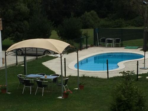 - une table avec un parasol à côté de la piscine dans l'établissement Finca Vistalpas, à Mogro