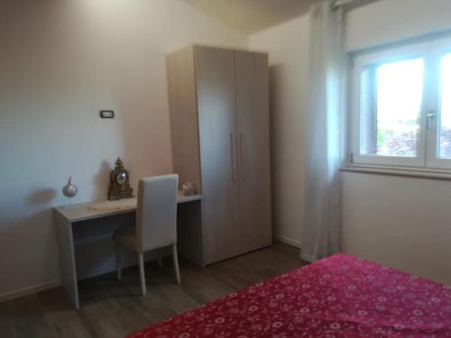 a bedroom with a desk and a cabinet and a window at Villa Ulivi in Filiano