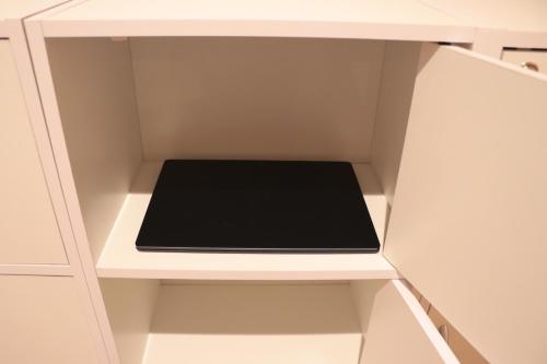 a white cupboard with a black book in it at Mezame Hostel in Nagasaki