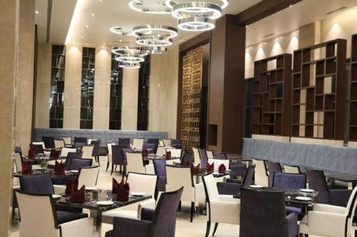 une salle à manger avec tables et chaises dans un bâtiment dans l'établissement Kiranshree Grand, à Guwahati