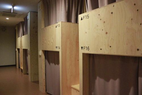 a row of wooden boxes on the wall of a room at Mezame Hostel in Nagasaki