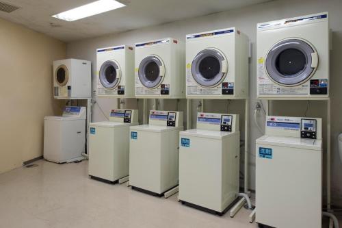 a row of washers and dryers in a room at Izumigo AMBIENT Azumino Hotel in Azumino